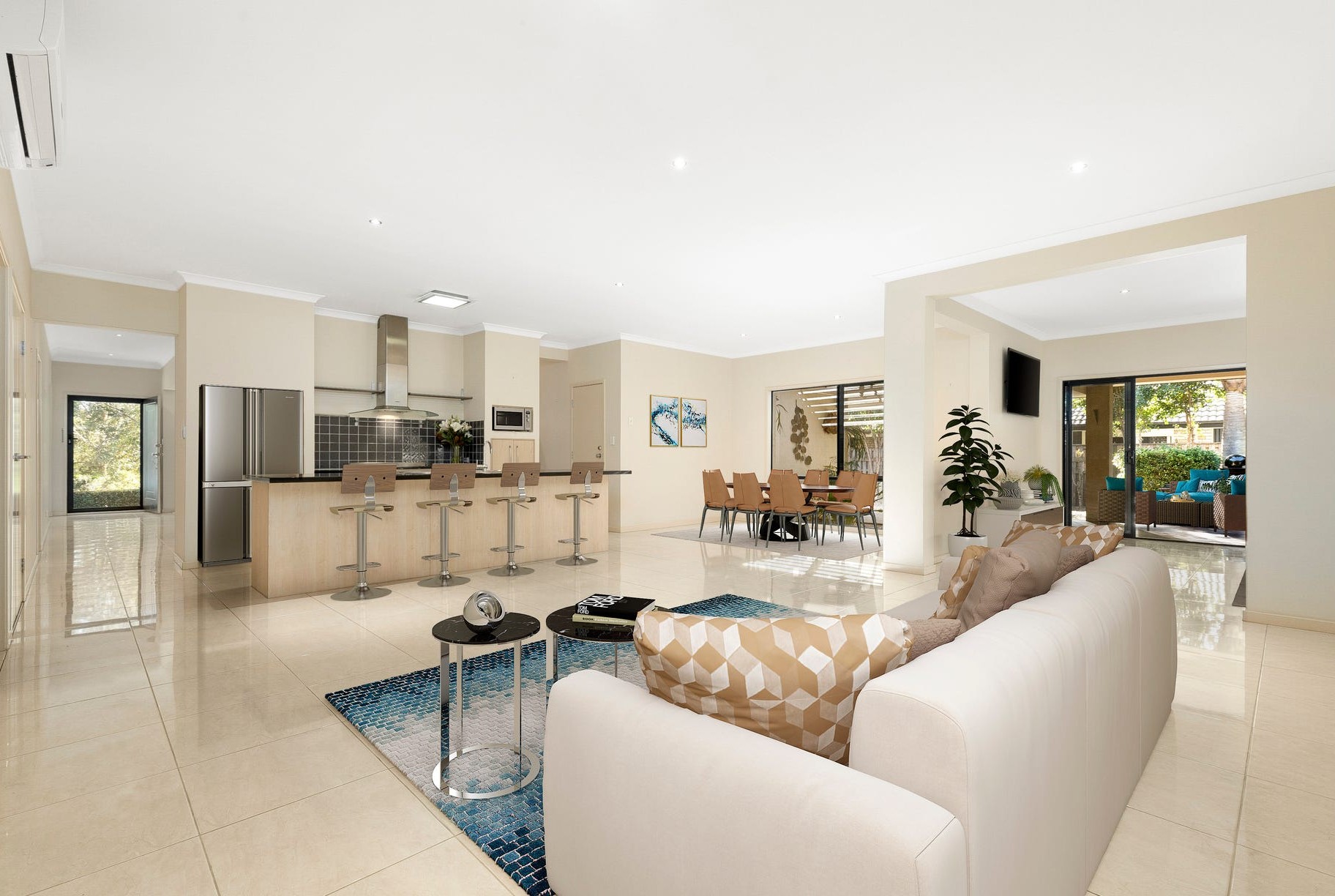 Open-plan kitchen, dining and living area with a breakfast bar and comfortable seating
