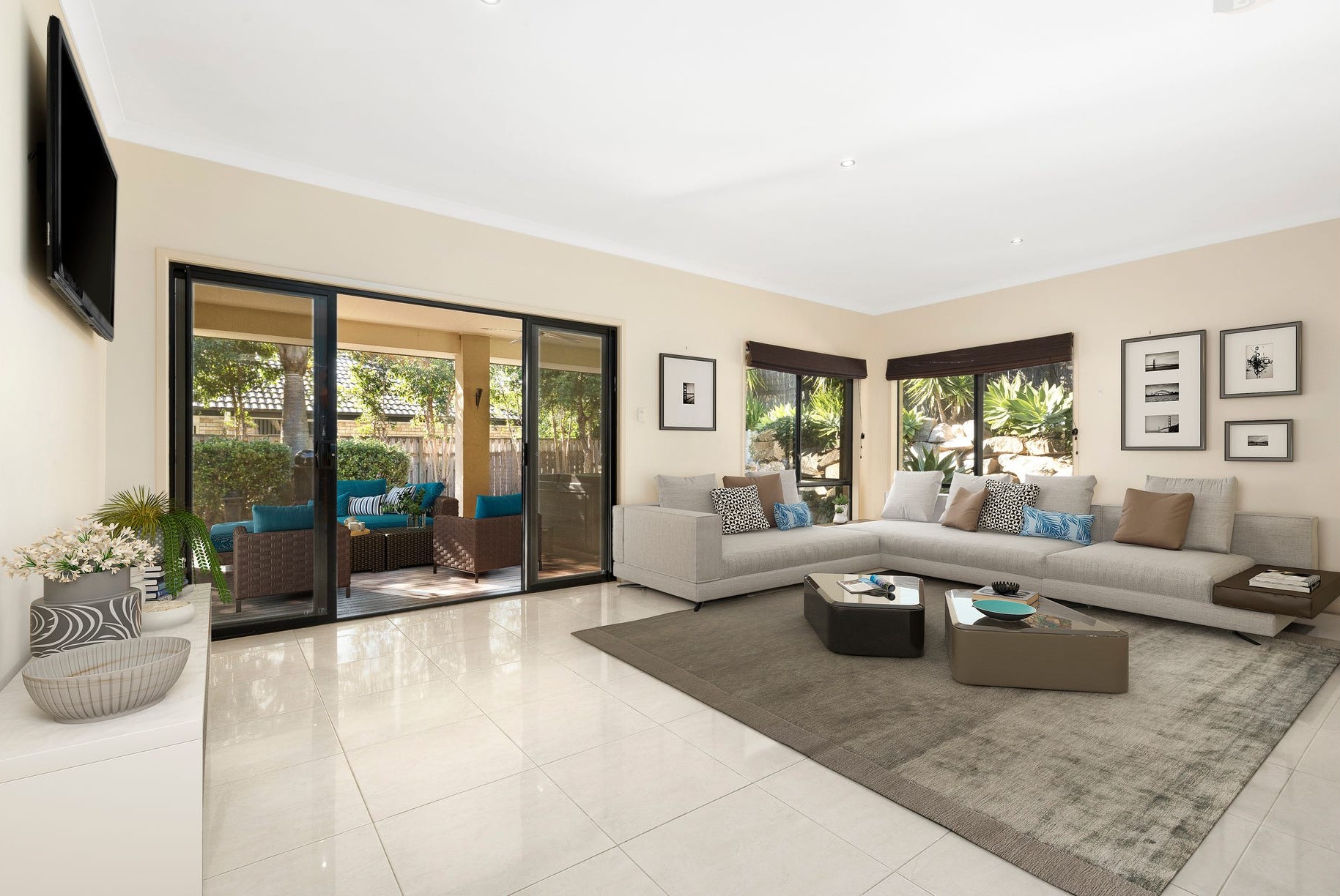 Second living room with a large sofa and sliding doors opening onto the covered outdoor area