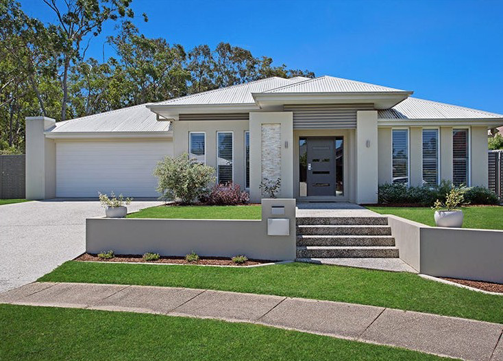 Front of SIL home 1, with a light-coloured facade, landscaped garden and central entrance